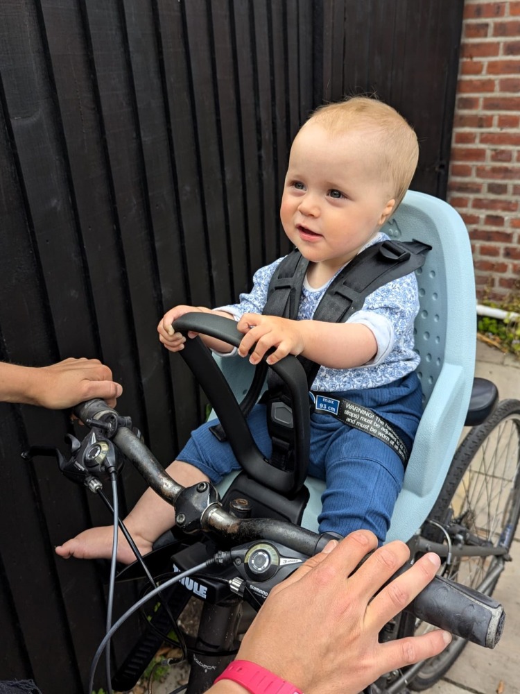 Cycling while breastfeeding: A baby in a front-mounted child seat on a bike