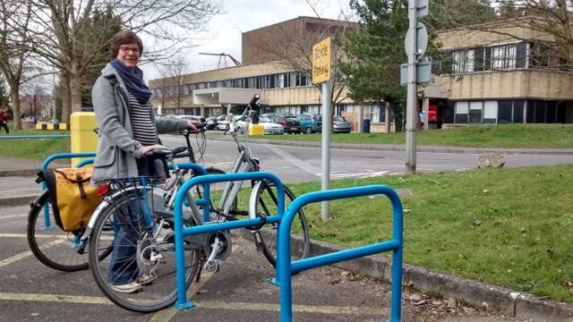 Saskia Heijltjes pictured while pregnant, standing with her bike next to some bike stands.