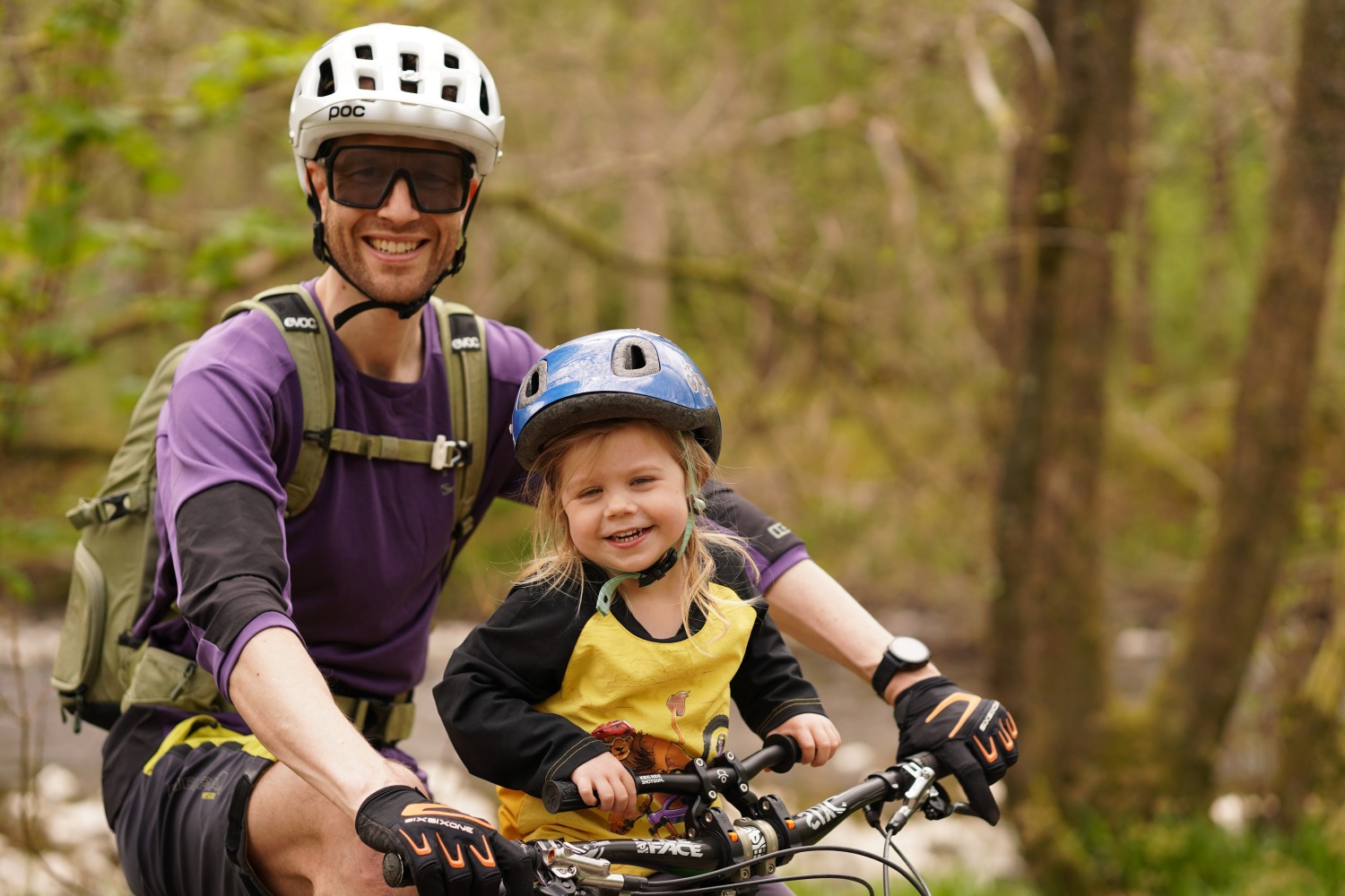 Kids Ride Shotgun seat review, daughter in a yellow top with her dad in the forest