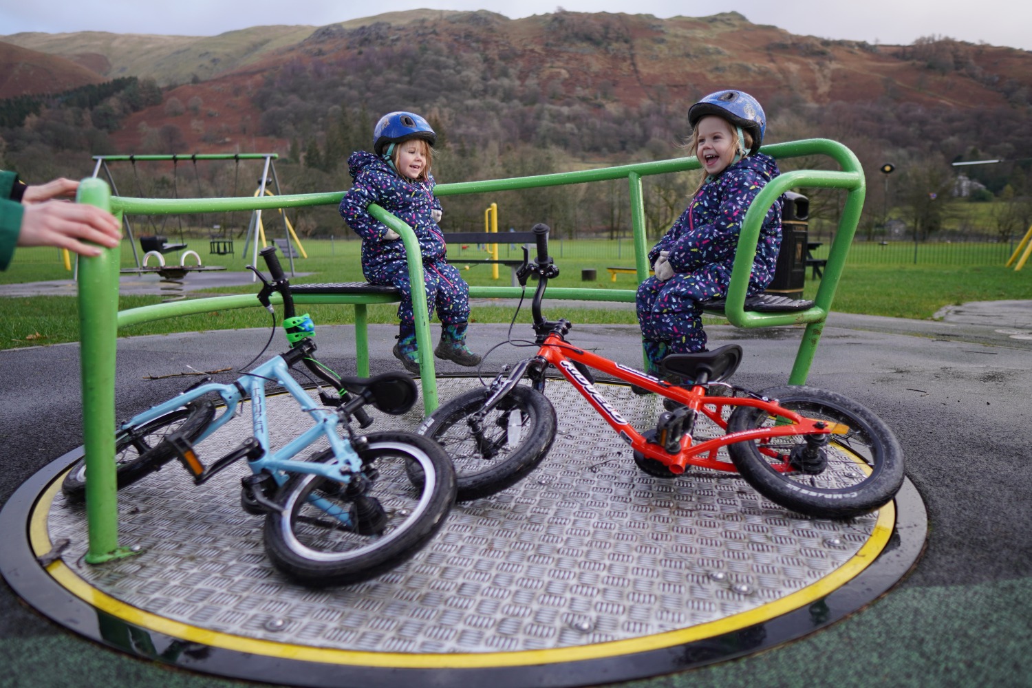 twin sisters on a roundabout with their bikes