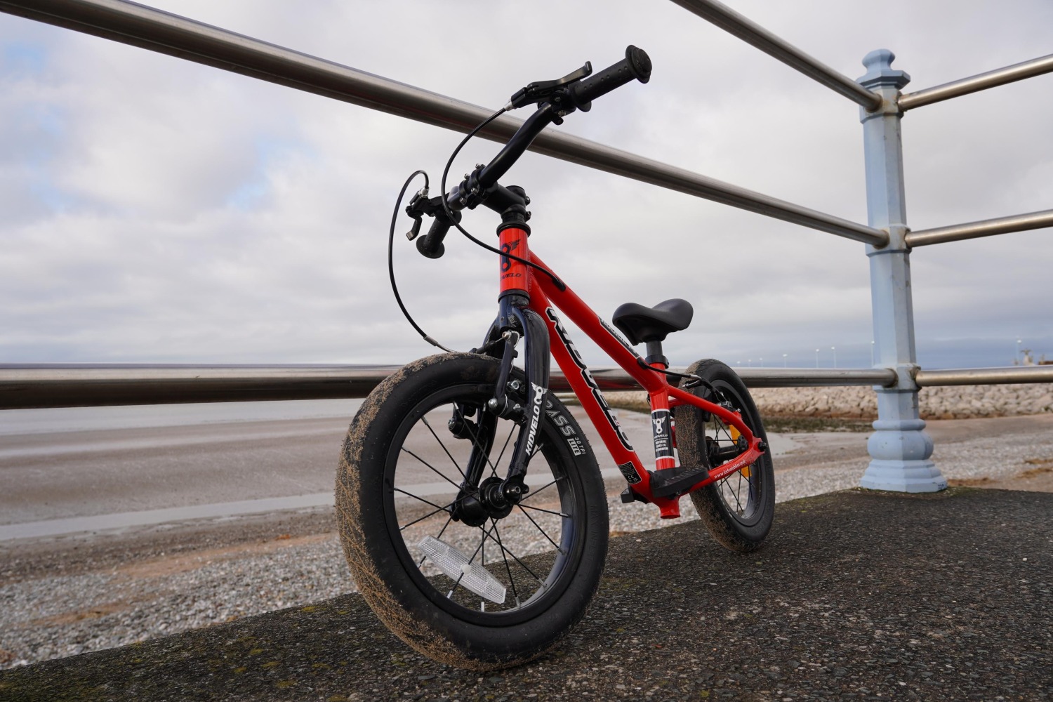 A red Kidvelo rookie leant up agaisnt a fence by the beach