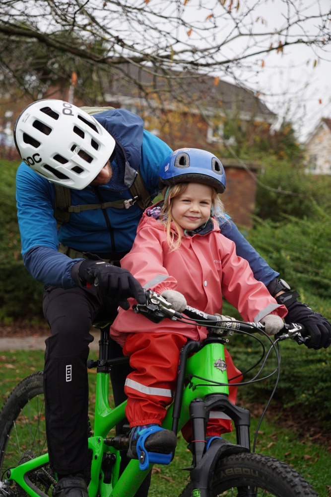 a dad and daughter on a bike ride smiling