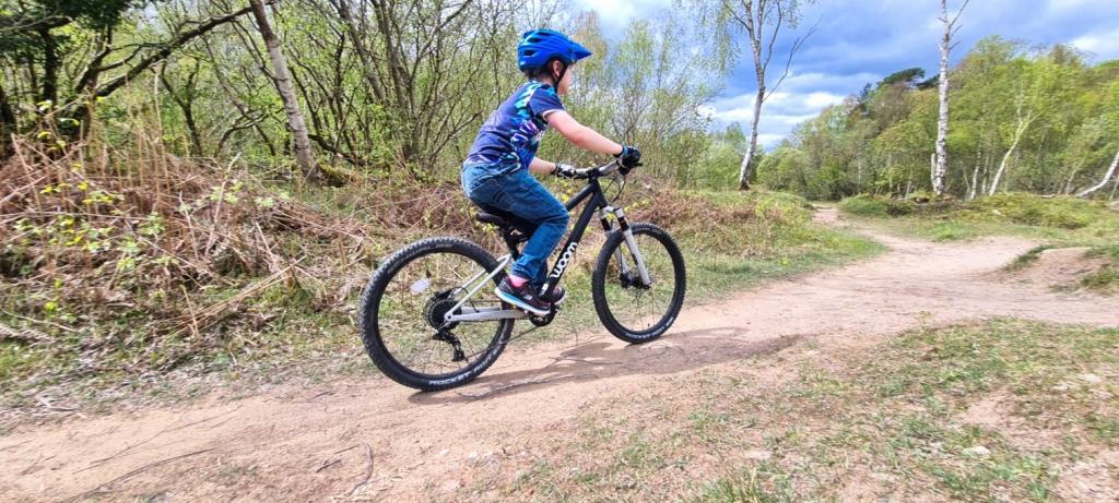 woom OFF AIR 5 review: boy riding a woom mountain bike on a dirt trail