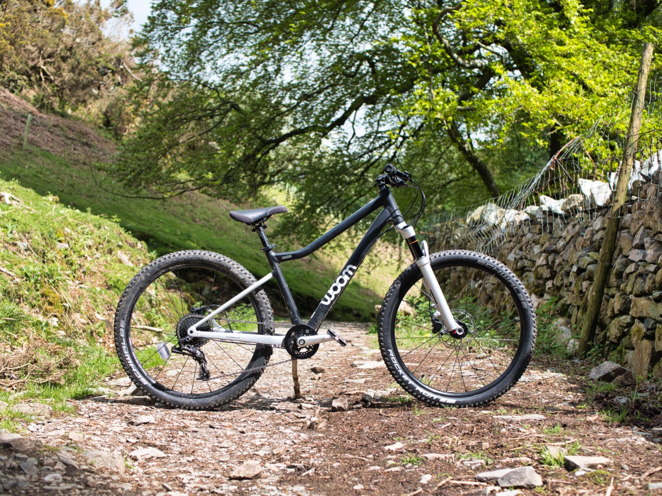 woom OFF AIR 5 review: The woom OFF AIR 5 mountain bike pictured side-on, on a mountain bike trail