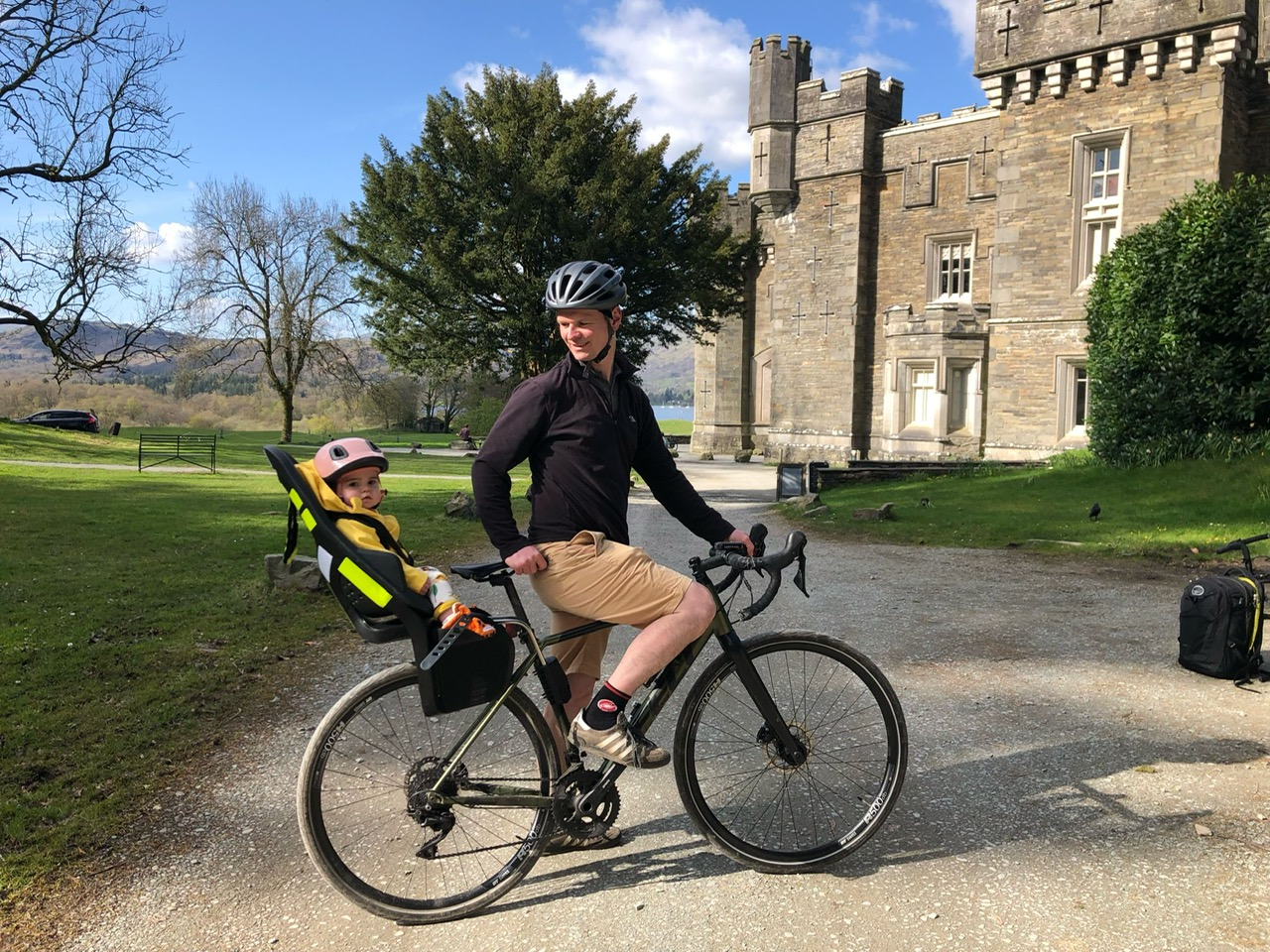 Dad and daugher on a bike ride in front of a castle