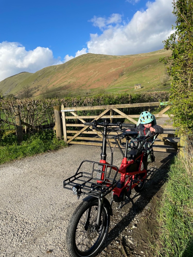 estarli ecargo longtail bike parked up by a gate in the hilly countryside on a sunny day