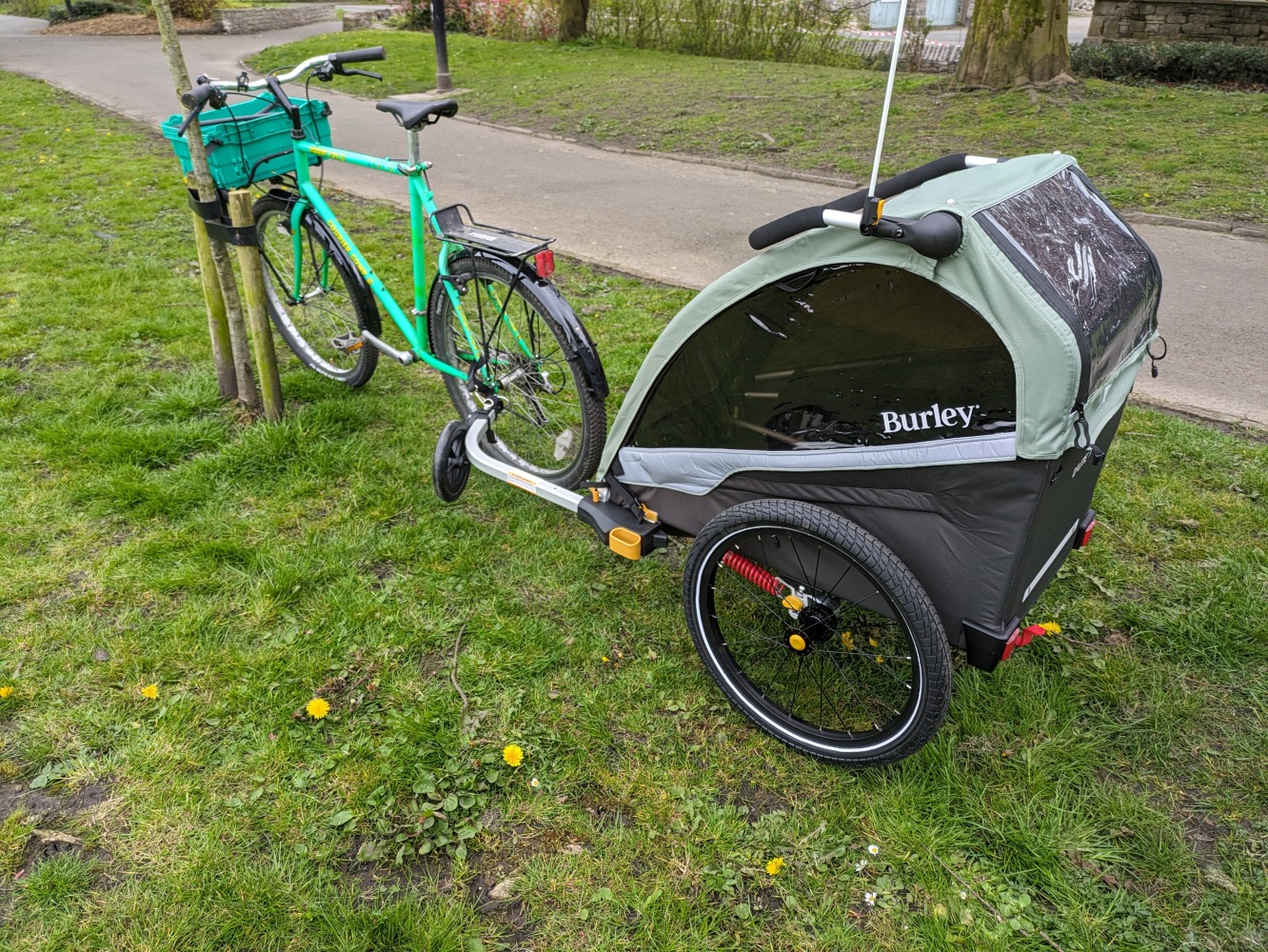 Picture showing the Burley D'Lite X child trailer hitched to a green bike