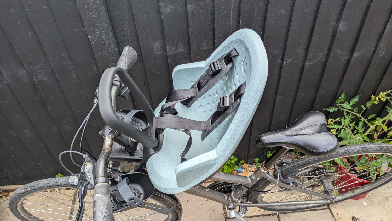 Thule Yepp 2 mini review: The blue seat is fitted to a black bike leant against a fence