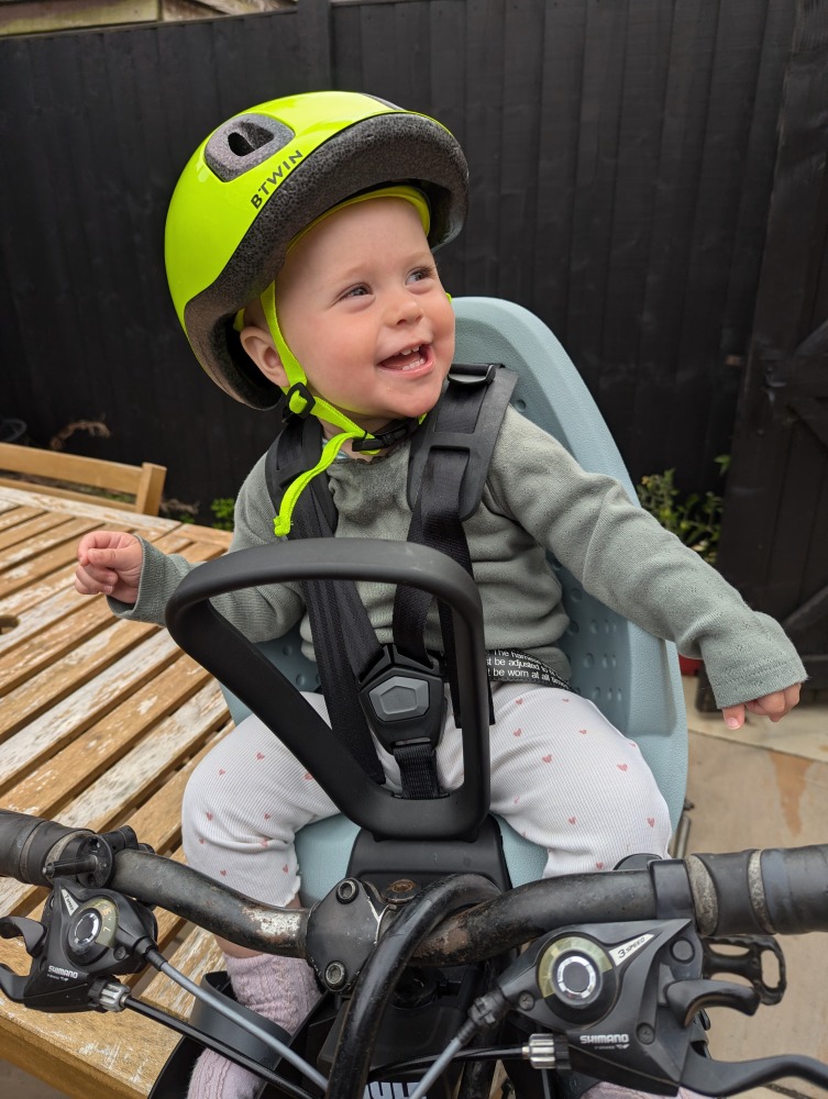 Thule Yepp 2 mini review: a little girl in a yellow helmet sat in a Thule Yepp 2 Mini front bike seat