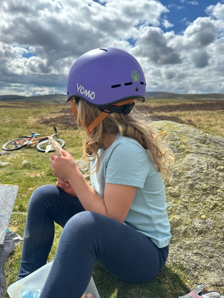 a blonde girl is looking away from the camera with a purple yomo helmet on