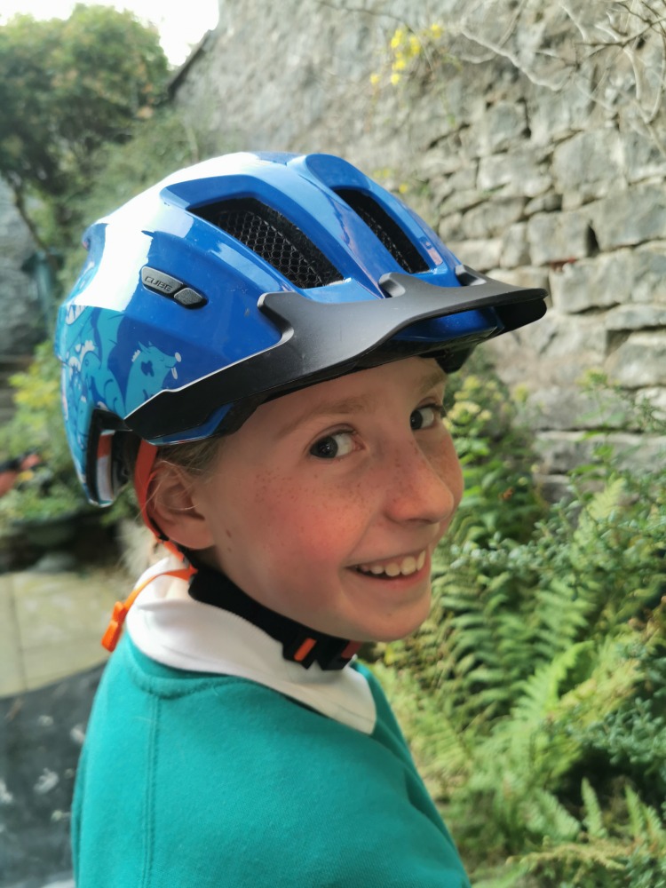 Cube ANT helmet, in blue, being worn by a girl in her school jumper