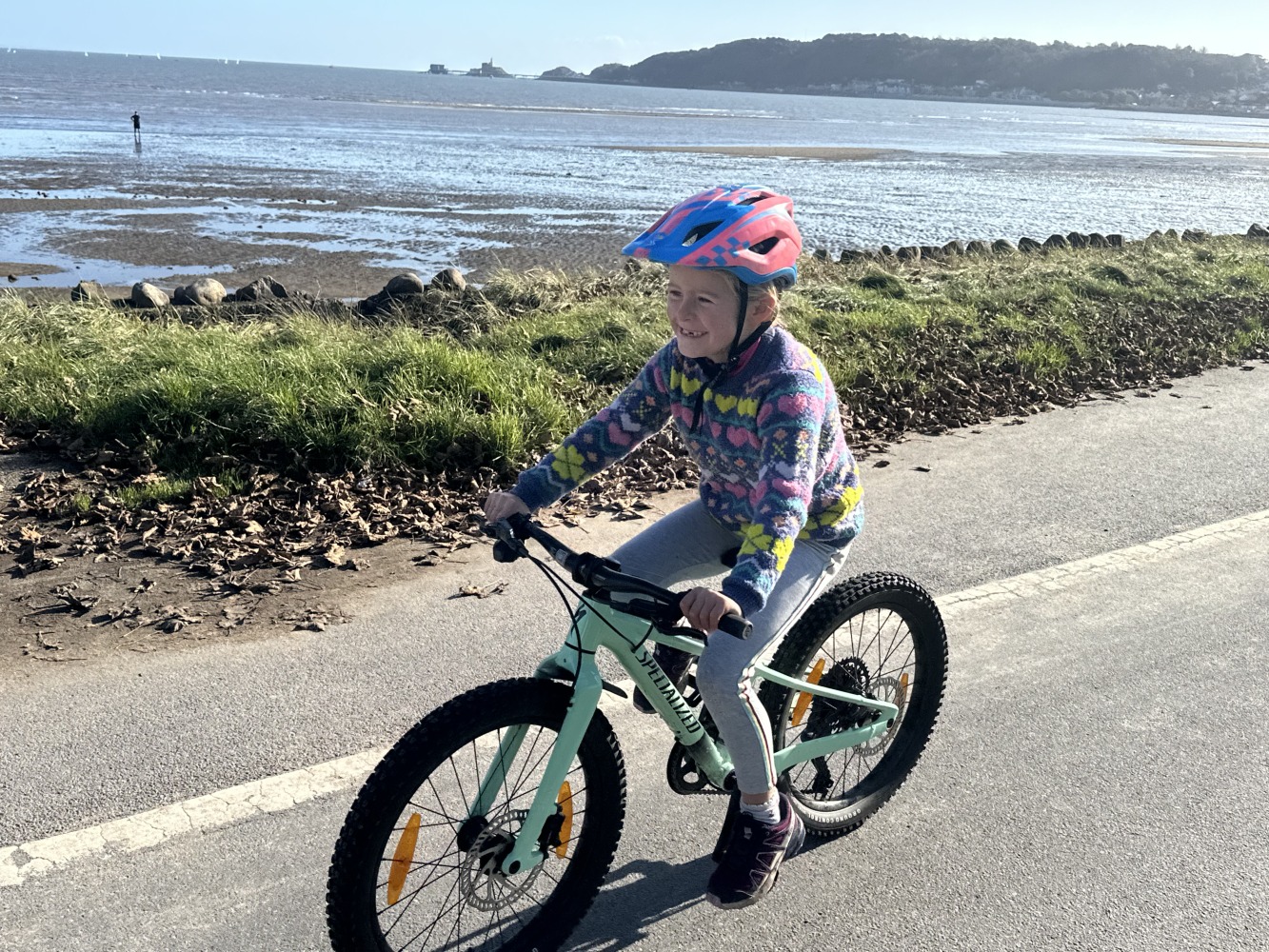 Specialized Riprock 20 review- a photo of a litle girl riding the blue bike next to the sea