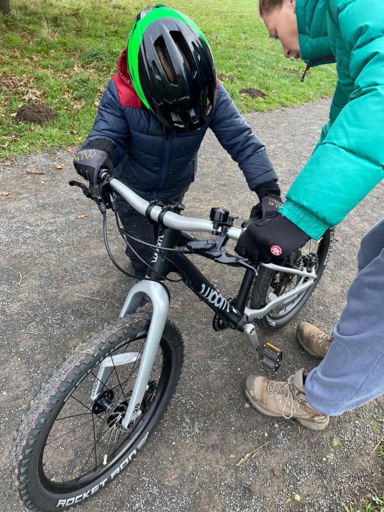 our woom off 4 reviewer Zack looking at his bike with his mum, working out how to change gears