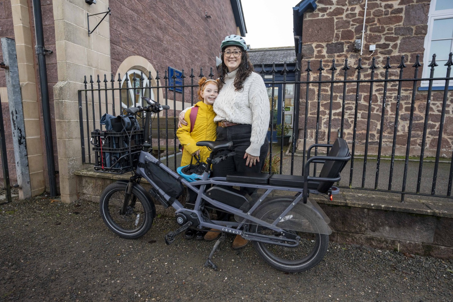 Lydia with her child in front of school standing behind their estarli ecargo bike