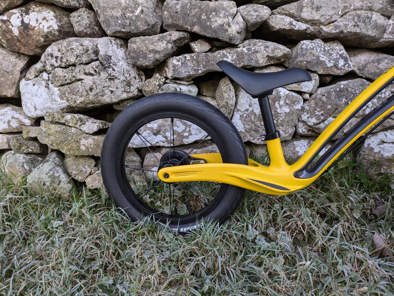 Hornit AIRO 14 review- a close up of the yellow bike against a stone wall - rear wheel showing