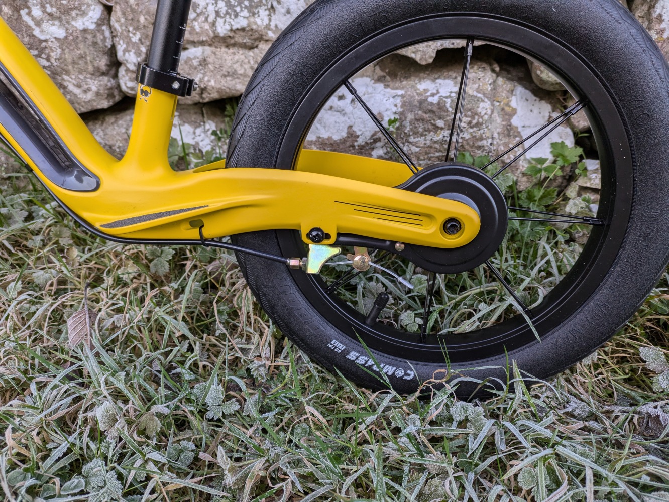 Hornit AIRO 14 review- a close up of the yellow bike against a stone wall showing the rear brake