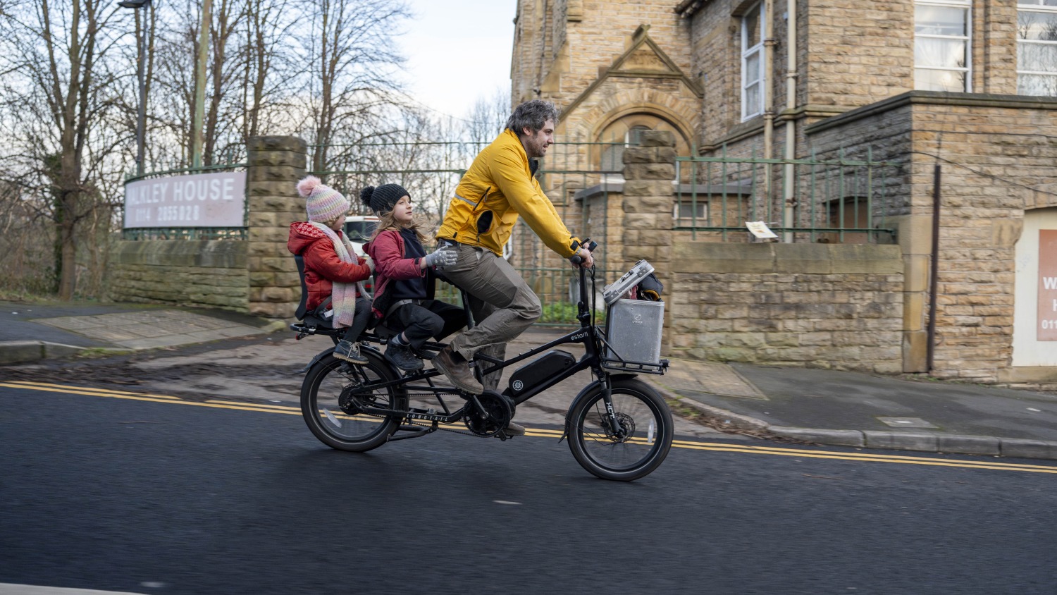 Simon with his two children on an estarli longtail cargo bike riding downhill